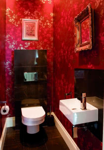czerwona tapeta na ścianach toalety.