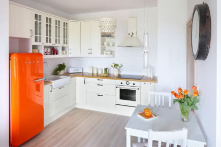 Jasne wnętrze w stylu skandynawskim z koloroawymi dodatkami - biała kuchnia z kolorowa lodówką