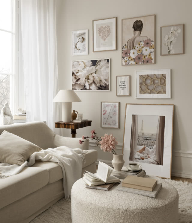 salon w beżach, ściana pełna grafik, jeden duży obraz stoi na podłodze