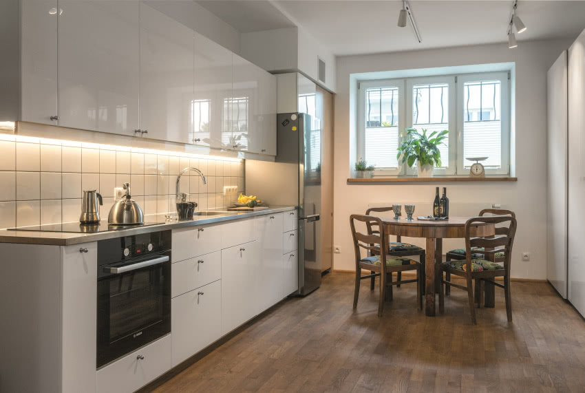 Biała kuchnia Tomka zamieszkującego parter. Stół...