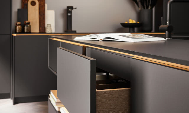 wyspa kuchenna, czarne fronty kuchenne, czarna bateria zlewozmywakowa, jodełka na podłodze, książka kucharska, szuflada