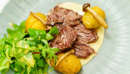 Świeczka wołowa marynowana w rozmarynie i Bourbonie, smażona i podana z pieczonymi francuskimi ziemniakami, tahini, salsa verde i mesclun z winegretem