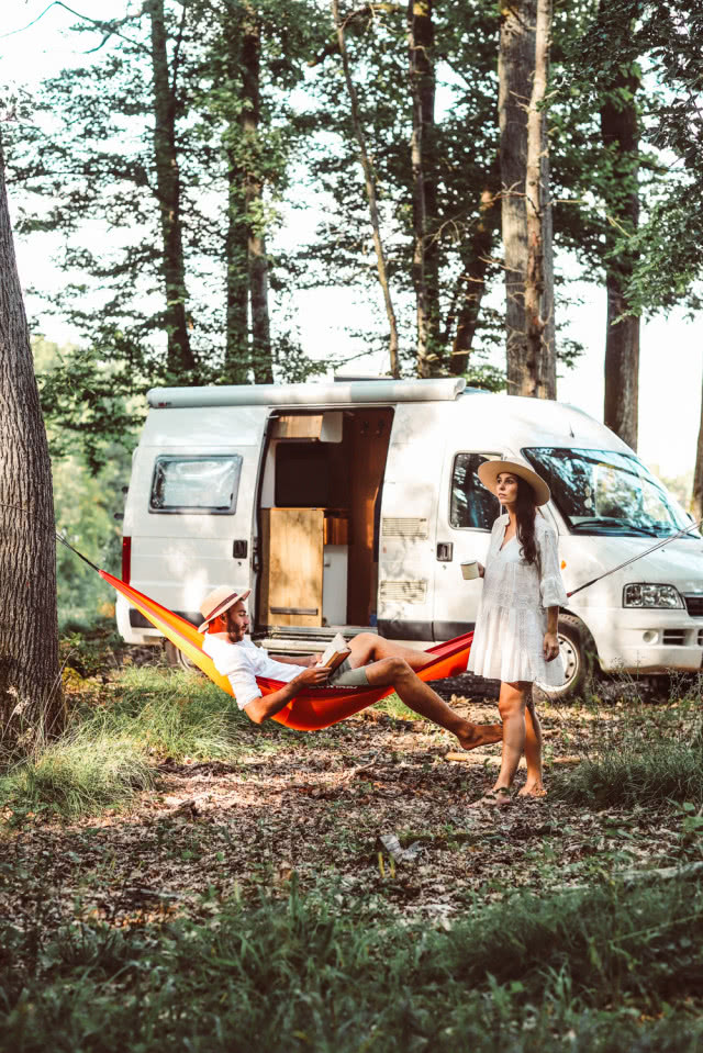 kamper na campingu z turystami na hamaku