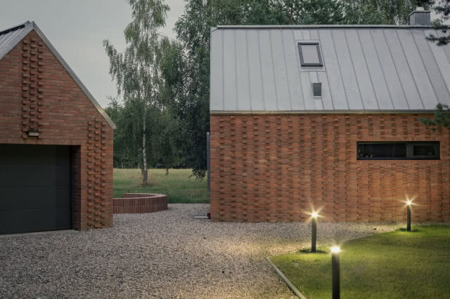 dwa budynki o zmierzchu z zapalonymi latarenkami