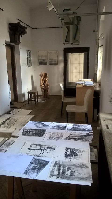 stół ze szkicami, widok na pracownię