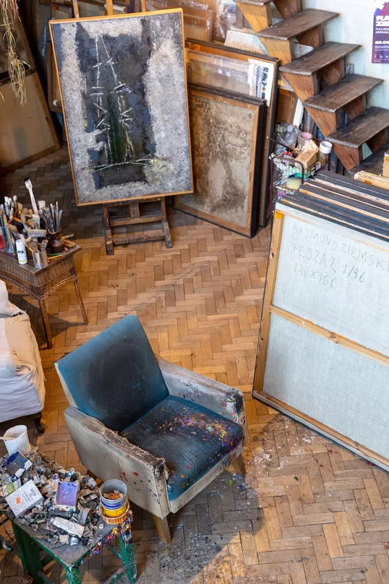 fotel zachlapany farbami stoi obok stolika