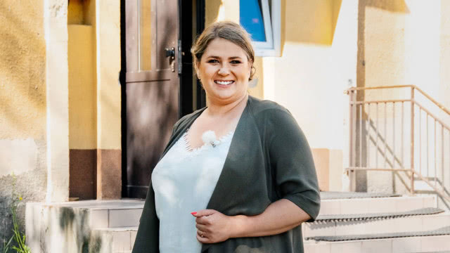 Elżbieta Romanowska w białej bluzce i szarym swetrze