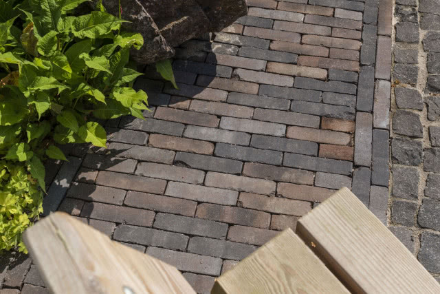 Kostka brukowa Antica, drewniana ławka, zielone kwiaty