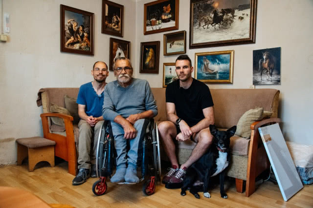 Pan Zbigniew z synami, w tle obrazy