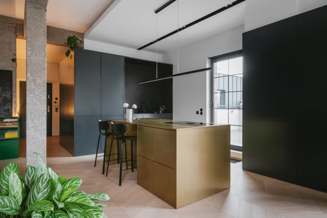 Złota wyspa kuchenna w czarnej kuchni