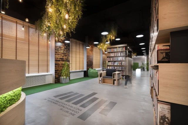 widok z oddali, regały i zieleń u sufitu