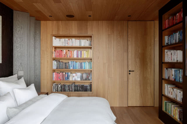 drewniana zabudowa w sypialni z biblioteką
