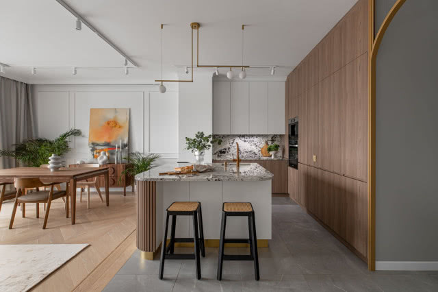 Biała kuchnia z dodatkiem drewna i hokerami z plecionki wiedeńskiej