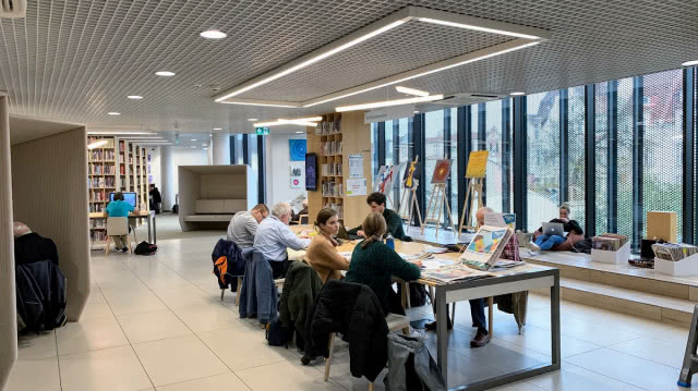 stół z ludźmi, nad stołem duży płaski lampa