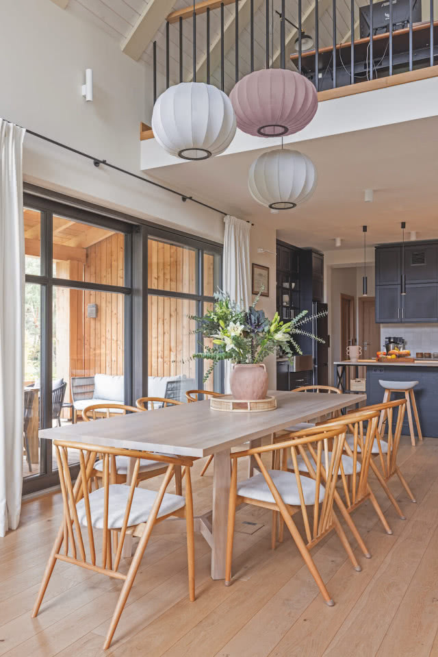 W centrum jadalni stół od wood-i oraz  minimalistyczne krzesła Jysk