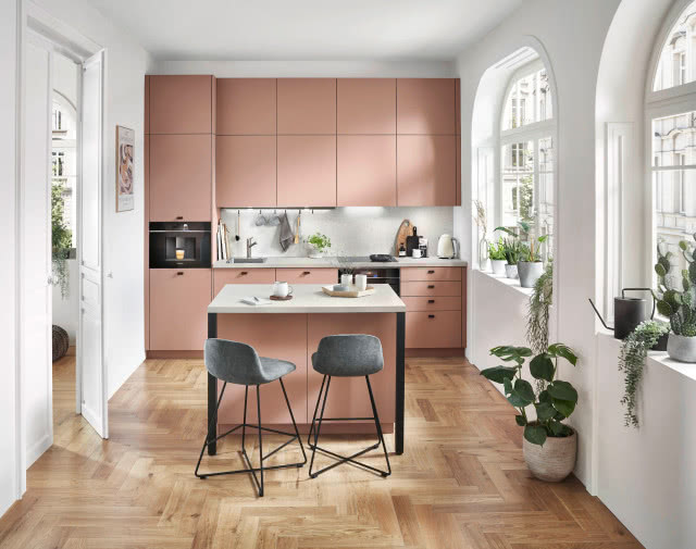 mała wyspa kuchenna z przedłużonym blatem dwa krzesła barowe, jodełka na podłodze 