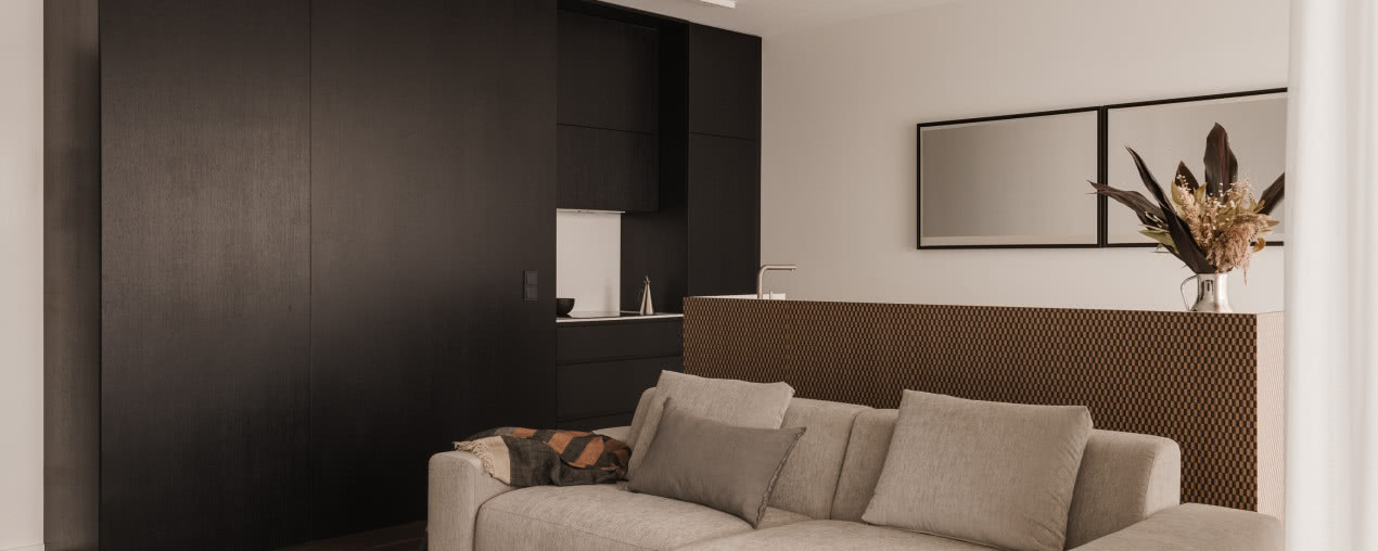 Łódzkie mieszkanie w stonowanych barwach. Ma trójwymiarową wyspę kuchenną!