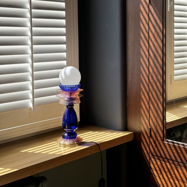 granatowa lampa stojąca na parapecie