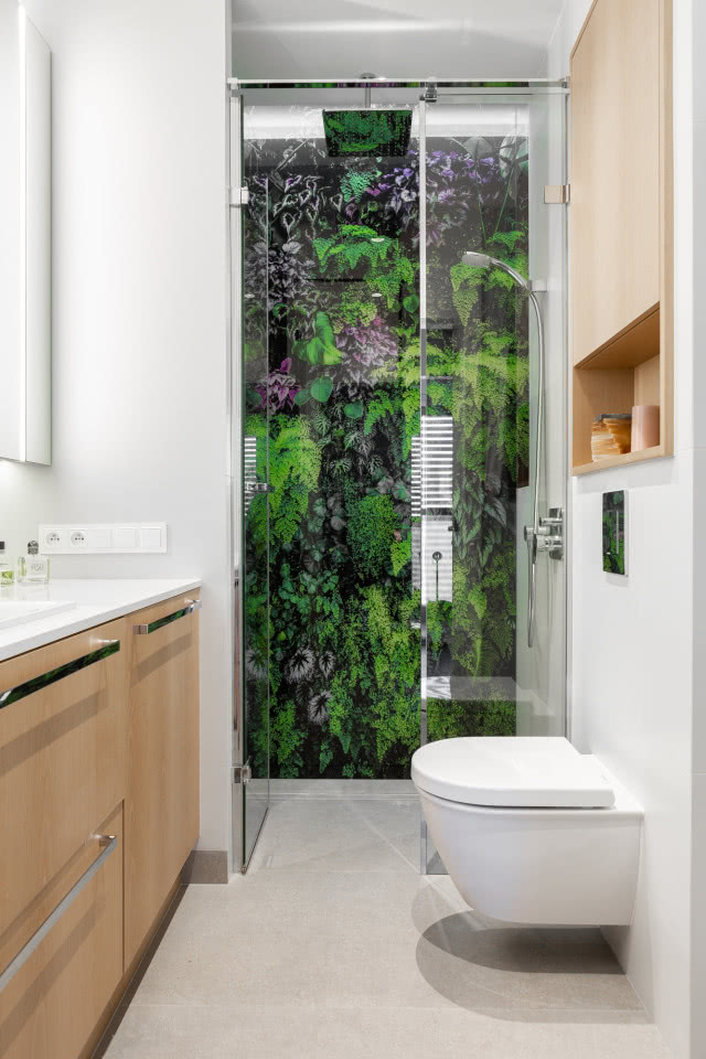 W łazience pojawiła się szklana ściana z nadrukiem przedstawiającym bujną roślinność, wykonanym na zamówienie przez firmę Projekt szkło – Grzegorz Buczyński. Przypomina
ona zieleń, którą właścicielka miała za oknem
w poprzednim domu.