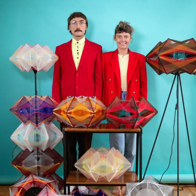 portret kobiety i mężczyzny na tle niebieskiej ściany z lampami