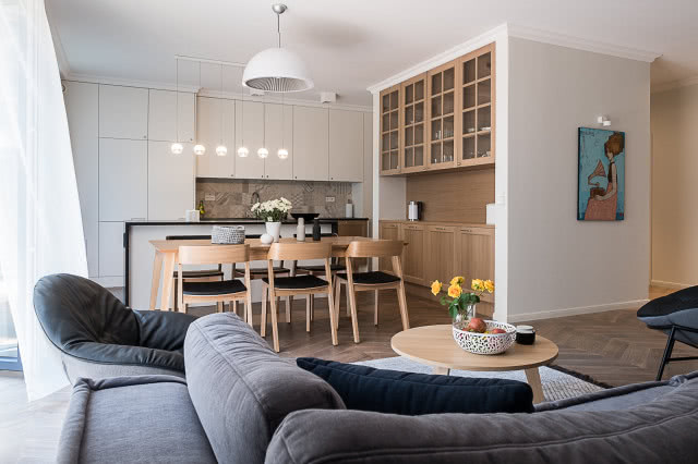 Salon z kuchnią w bieli i ciepłym drewnie