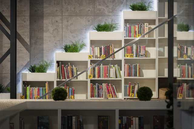 szklana barierka schodów na tle regałów