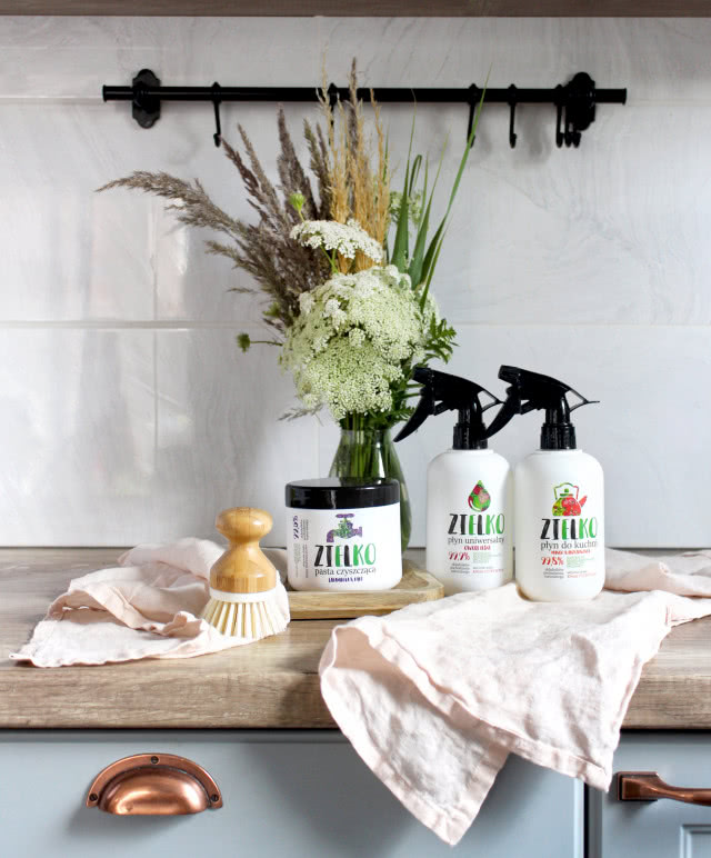 Naturalne i ekologiczne środki czystości marki ZIELKO, kwiaty, wazon, drewniany blat, ścierki kuchenne, wieszak kuchenny, mosiężne uchwyty, miętowe fronty kuchenne