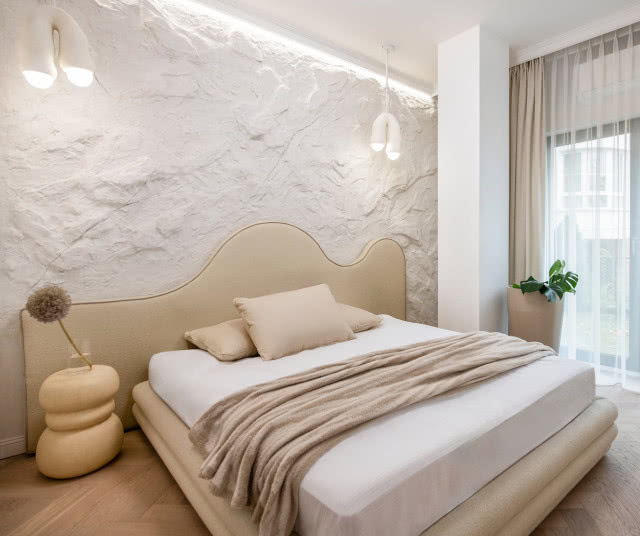 kamienna ściana za łóżkiem w sypialni