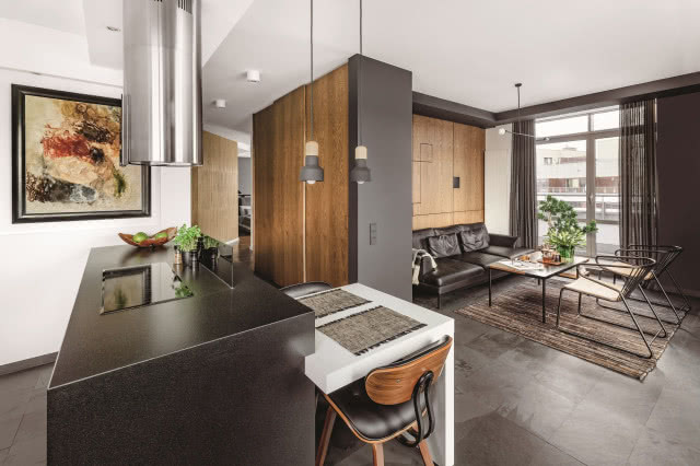 Czarna wyspa kuchenna oddzielająca salon od kuchni