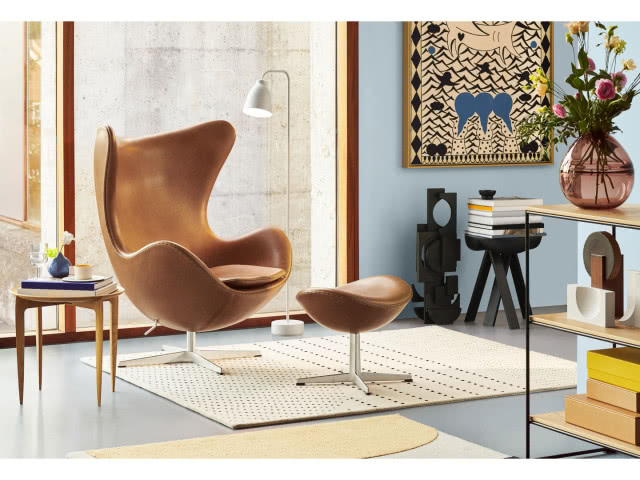 musztardowy fotel z podnóżkiem, na ścianie gobelin