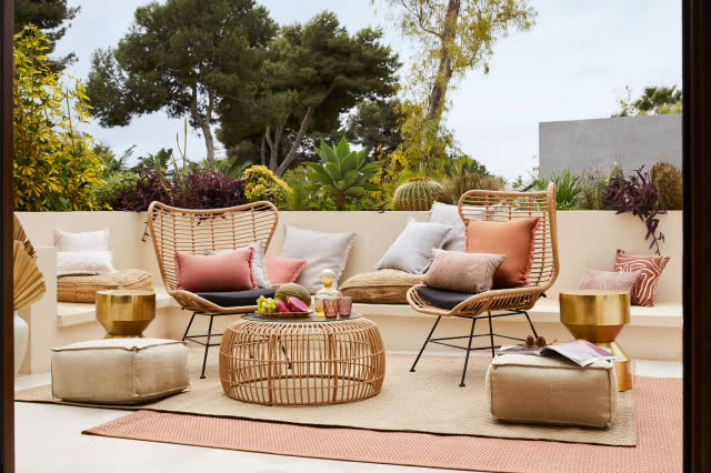 balkon z rattanowymi krzesłami i pastelowymi dodatkami