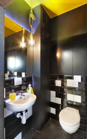 Gościnna toaleta urządzona w odcieniach czerni, bieli i żółci