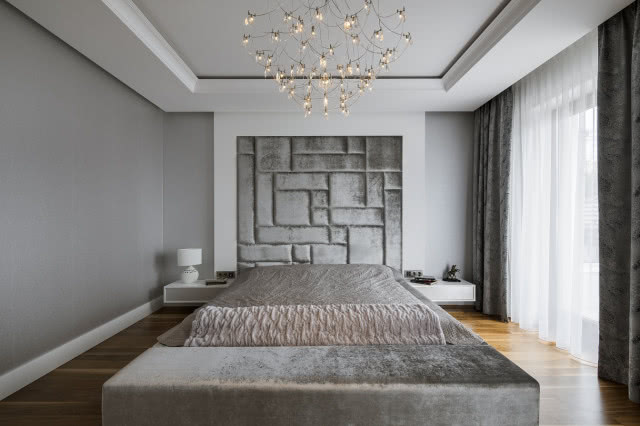 Aksamitny zagłówek w łóżku w sypialni