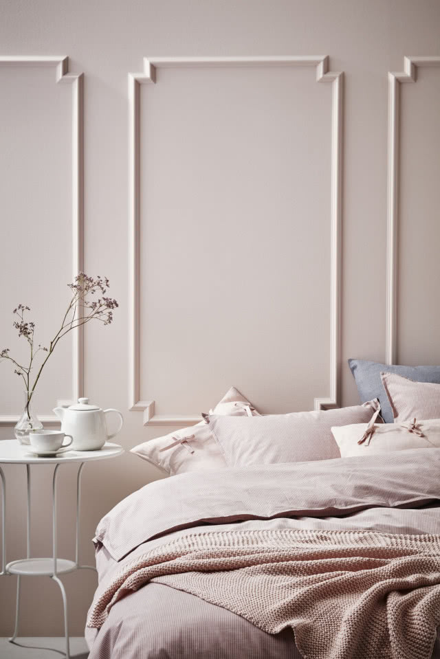 Różowa sypialnia ze sztukaterią na ścianie