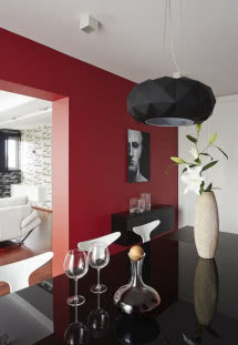 Jadalnia. Czarny stół z hartowanego szkła, biała szafa i czerwona ściana
