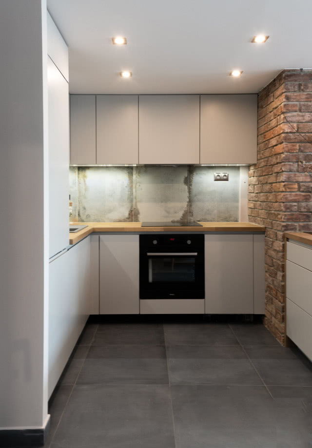 Minimalistyczna kuchnia z cegłą na ścianie
