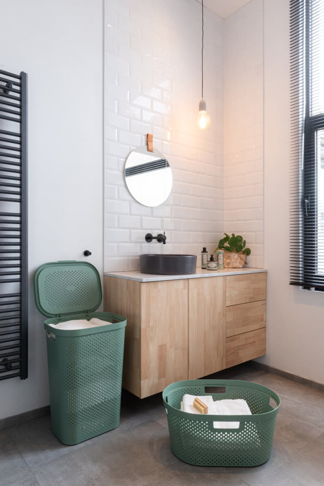 wysoki kosz na brudne pranie, kosz  na czyste prawnie, drewniana szafka podumywalkowa, umywalka nablatowa, lustro, grzejnik drabinkowy