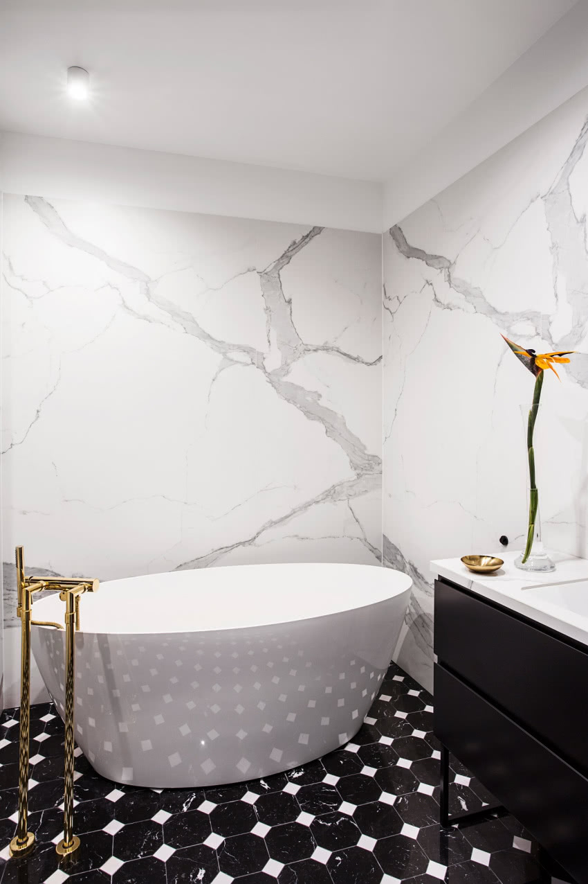 Czarno biała łazienka ze złotą armaturą to...