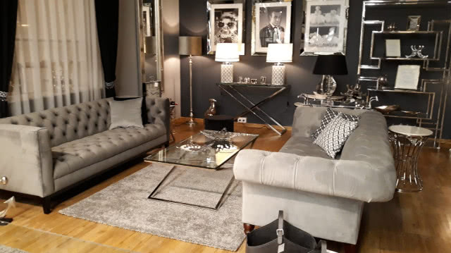 Nowy salon Dekorii w Warszawie! szare kanapy, sofy, szklany stolik kawowy, metalowe półki, czarno-białe obrazy na ścianie, ciemno szara ściana