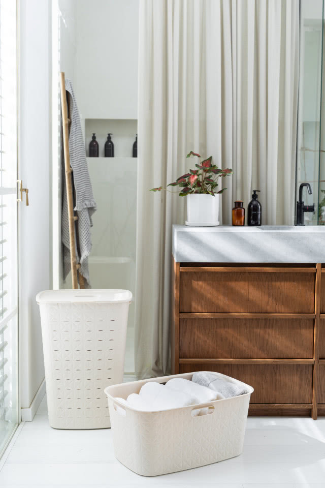 wysoki kosz na brudne pranie, kosz  na czyste prawnie, drewniana szafka podumywalkowa, lustro, grzejnik drabinkowy