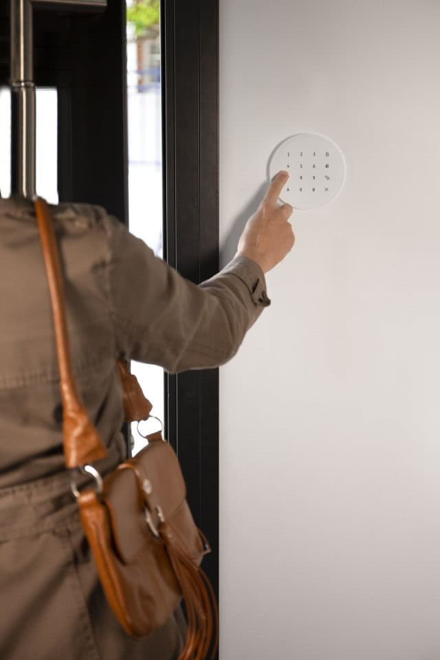 wychodząca kobieta włącza alarm