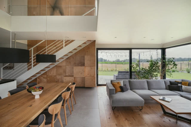 widok na fragment salony, schody i duże okno