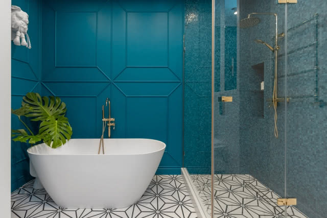 łazienka z niebieską ścianą i wzorzystymi płytkami na podłodze
