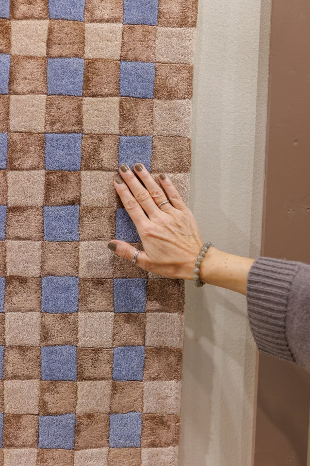 ręka kobieca głaszczę powierzchnię dywanu