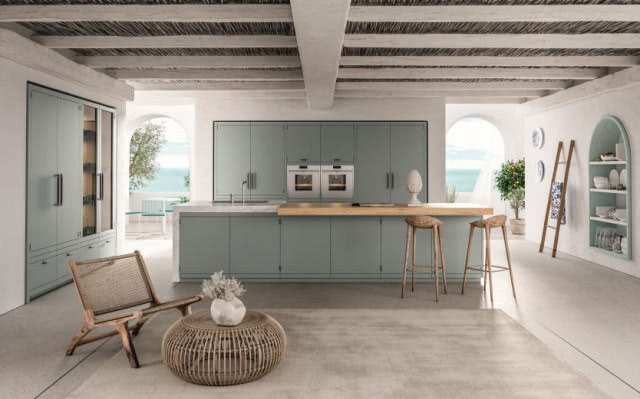 zielone fronty kuchenne,, piekarnik, wyspa kuchenna, lodówka, zlew, płyta grzewcza, stołki barowe, fotel, stolik kawowy, drabina, belki na suficie