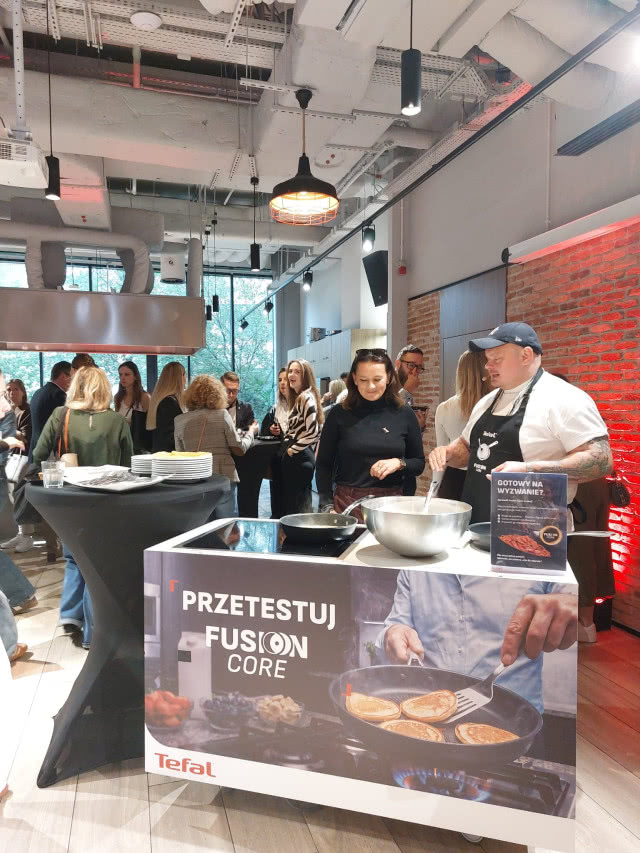 Testowanie patelni Tefal Fusion Core podczas wydarzenia kulinarnego z udziałem gości i szefa kuchni.