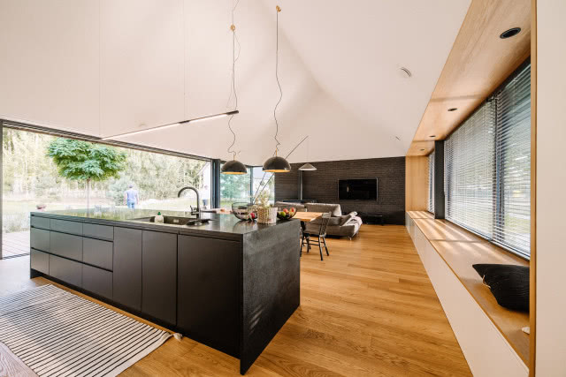 widok od strony kuchni na salon z przeszkleniami