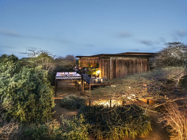 dom o zmierzchu, na tle drzew