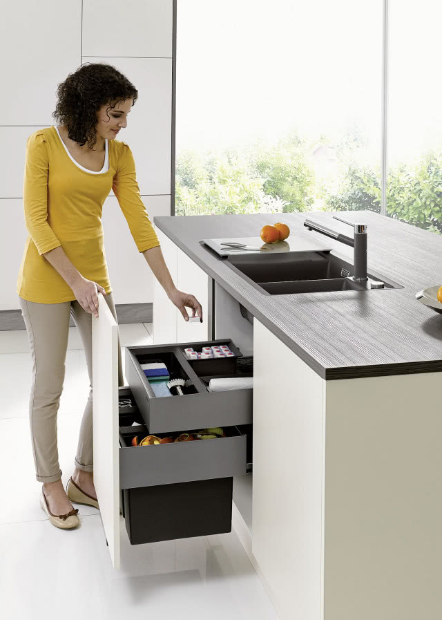 szaro-srebrna bateria kuchenna, szary zlew, ciemny drewniany blat kuchenny, szafki pod zlewem