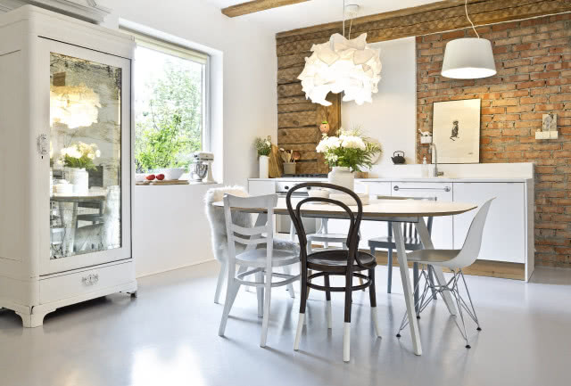 Biała kuchnia z naturalną cegłą na ścianie